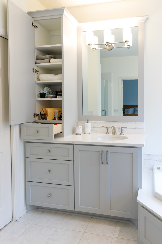 Inspiration for a medium sized traditional ensuite bathroom in Minneapolis with recessed-panel cabinets, grey cabinets, a corner bath, an alcove shower, a two-piece toilet, grey walls, ceramic flooring, a submerged sink, engineered stone worktops, grey floors, a hinged door, white worktops, an enclosed toilet, a single sink and a built in vanity unit.