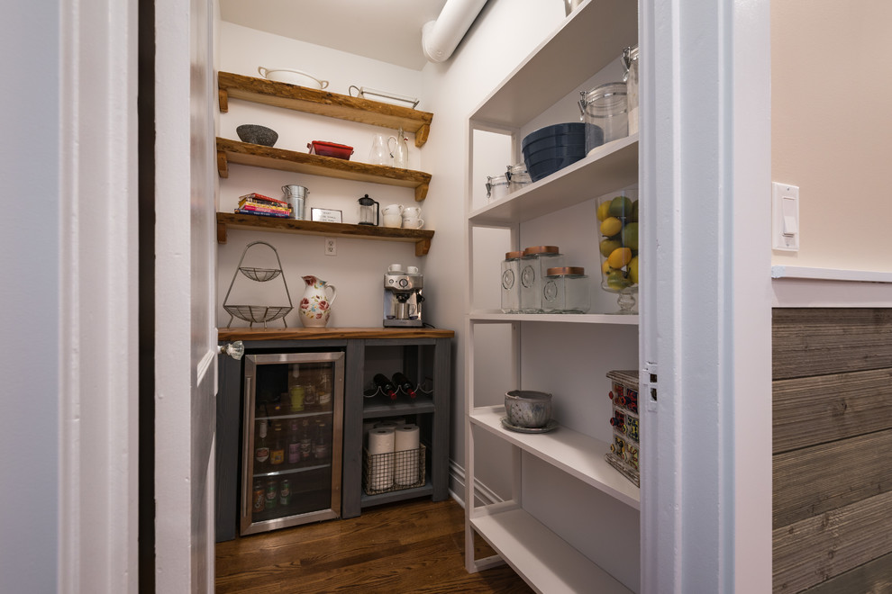 Small transitional l-shaped medium tone wood floor and brown floor kitchen pantry photo in Chicago with wood countertops, stainless steel appliances and no island