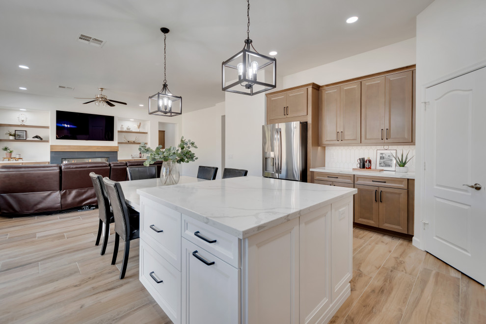 Mid-sized transitional u-shaped ceramic tile and brown floor eat-in kitchen photo in Phoenix with beaded inset cabinets, brown cabinets, quartzite countertops, white backsplash, ceramic backsplash, an island and white countertops