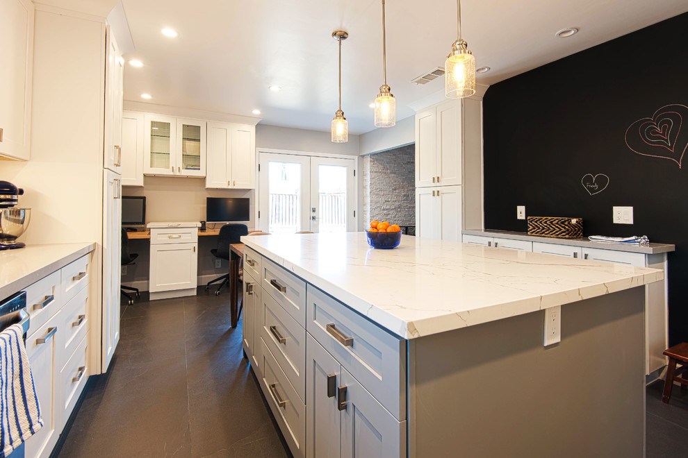Large modern u-shaped eat-in kitchen in San Francisco with an undermount sink, shaker cabinets, white cabinets, marble benchtops, white splashback, ceramic splashback, stainless steel appliances, slate floors, with island, black floor and white benchtop.