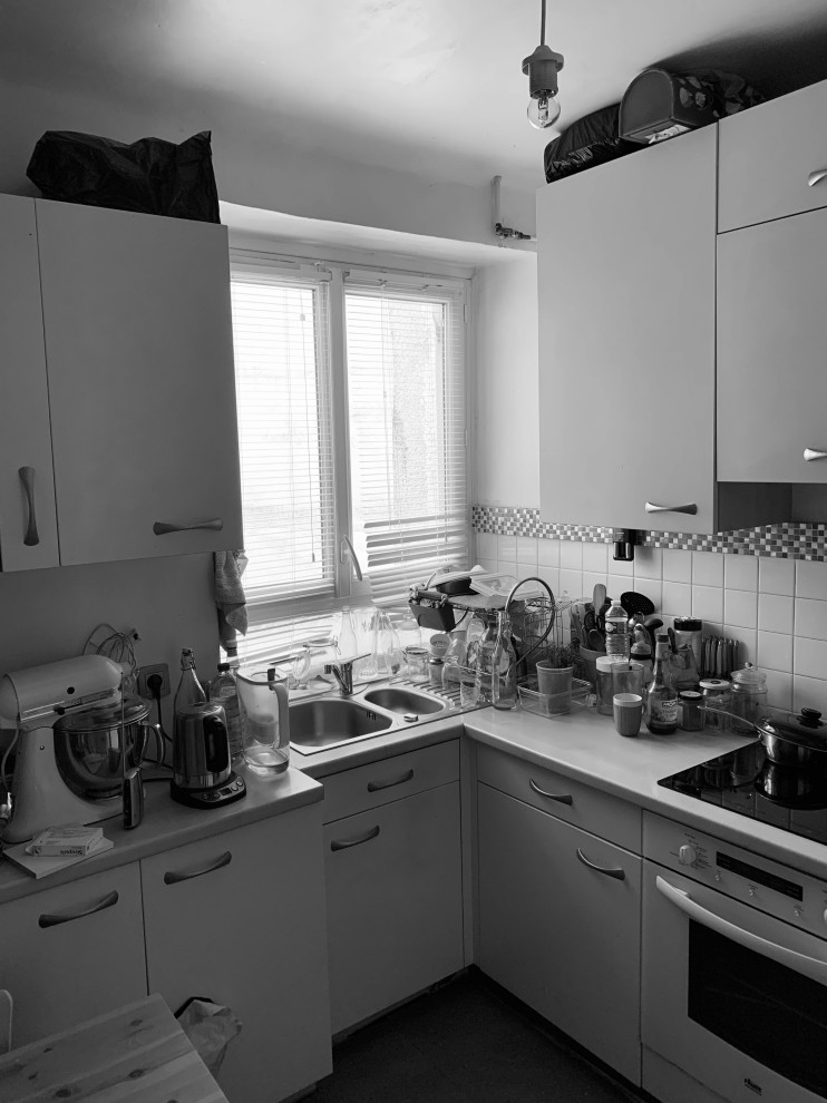 Cette photo montre une cuisine parallèle chic fermée avec un évier 1 bac, des portes de placard marrons, un plan de travail en bois, une crédence métallisée, une crédence miroir, un sol en terrazzo, un sol gris et un plan de travail marron.