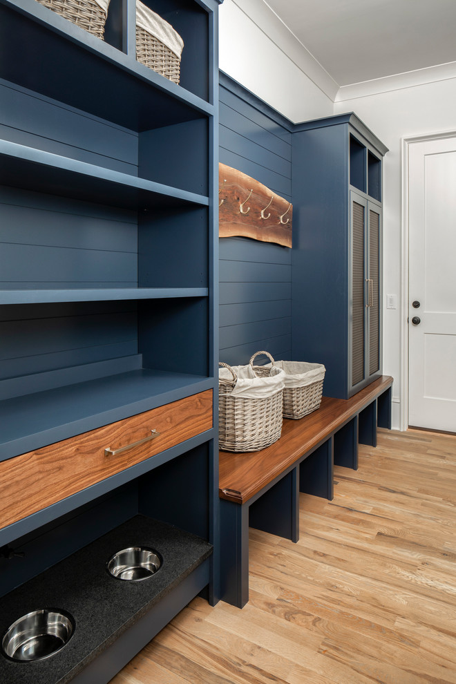 Inspiration for a mid-sized transitional mudroom in Charlotte with white walls and light hardwood floors.