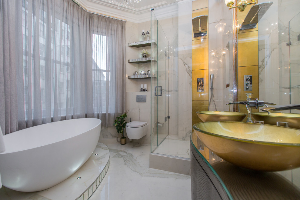 This is an example of a mid-sized contemporary master bathroom in London with a freestanding tub, a corner shower, a wall-mount toilet, marble, a vessel sink, white floor, flat-panel cabinets, dark wood cabinets, black and white tile, yellow tile, glass benchtops and a hinged shower door.