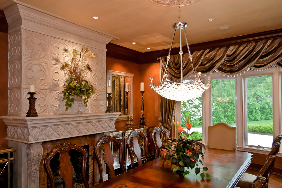 Traditional dining room in St Louis with orange walls and brown floor.