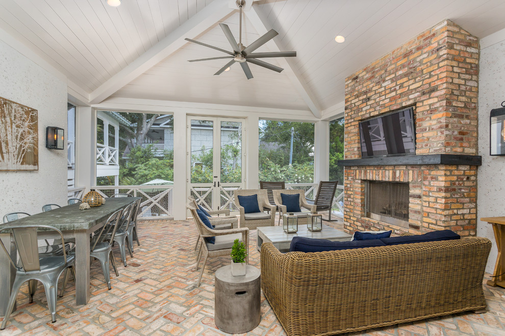 Inspiration for a beach style verandah in Jacksonville with a fire feature, brick pavers and a roof extension.