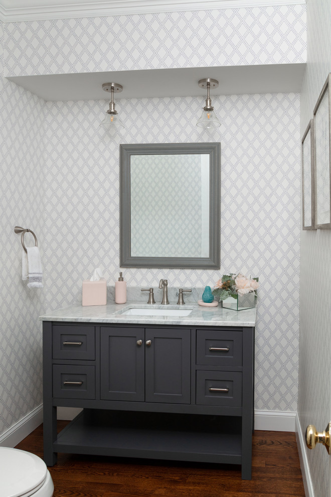 Design ideas for a small country powder room in Boston with shaker cabinets, grey cabinets, grey walls, medium hardwood floors, an undermount sink, marble benchtops, brown floor and white benchtops.