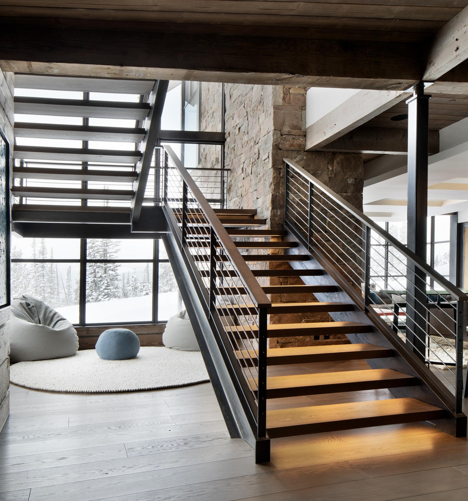 Imagen de escalera rústica con escalones de madera, contrahuellas de madera y barandilla de metal