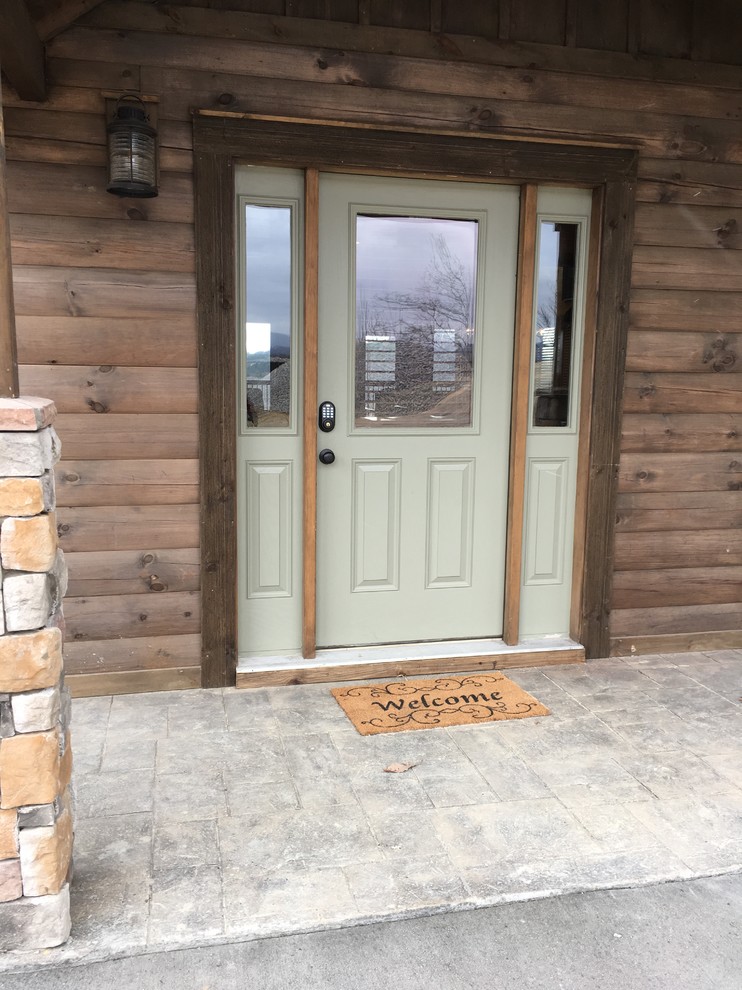 Front door - mid-sized rustic front door idea with brown walls and a green front door