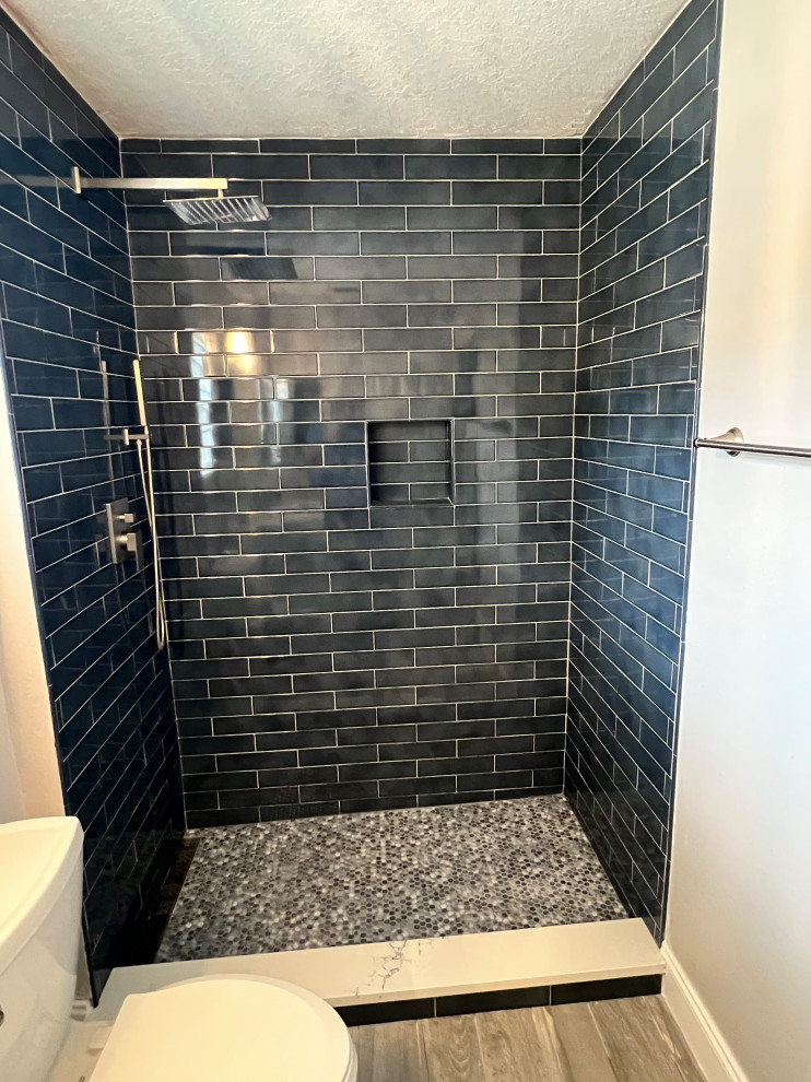Small classic shower room bathroom in Orlando with an alcove shower, blue tiles, ceramic tiles, grey walls, porcelain flooring, brown floors, a sliding door, a wall niche and a built in vanity unit.