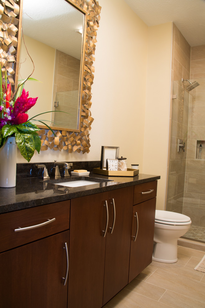 Alcove shower - mid-sized transitional 3/4 beige tile and ceramic tile ceramic tile alcove shower idea with flat-panel cabinets, dark wood cabinets, a two-piece toilet, beige walls, an undermount sink and granite countertops