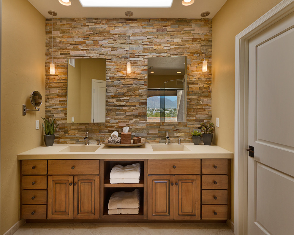 Design ideas for a traditional bathroom in Phoenix with an integrated sink, raised-panel cabinets, medium wood cabinets, engineered quartz benchtops and brown tile.