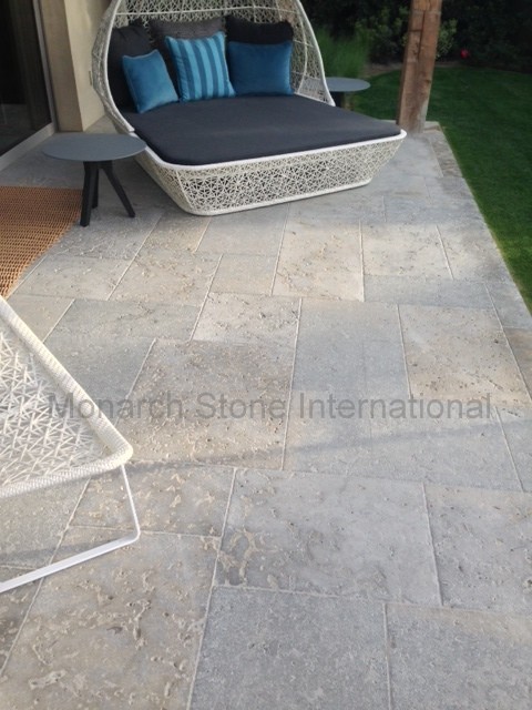 Design ideas for a mid-sized traditional backyard patio in Orange County with natural stone pavers.