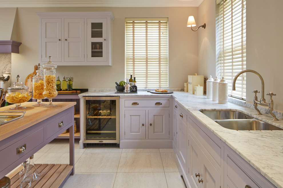 Inspiration for a large traditional l-shaped eat-in kitchen in Wiltshire with an undermount sink, raised-panel cabinets, marble benchtops, coloured appliances, porcelain floors and with island.