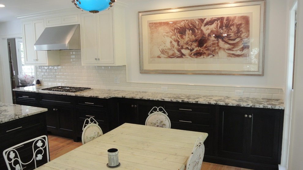 Inspiration for a transitional light wood floor eat-in kitchen remodel in Boston with an undermount sink, shaker cabinets, granite countertops, white backsplash, subway tile backsplash, stainless steel appliances and an island
