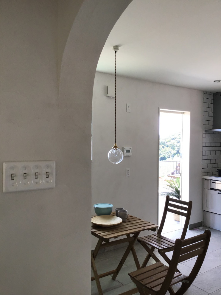 Idee per un grande angolo colazione rustico con pareti bianche, pavimento in terracotta e pavimento grigio