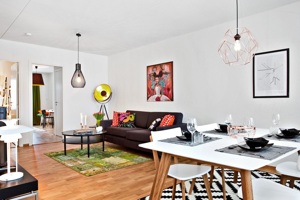 Photo of a small contemporary open concept living room in Stockholm with white walls, medium hardwood floors, no fireplace and no tv.