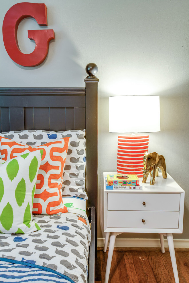 This is an example of a mid-sized midcentury kids' bedroom for kids 4-10 years old and boys in Dallas with grey walls and medium hardwood floors.