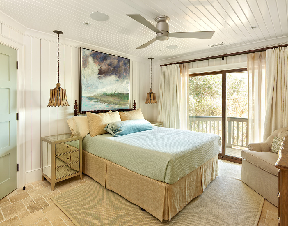 Photo of a beach style bedroom in Charleston with white walls, no fireplace and travertine floors.