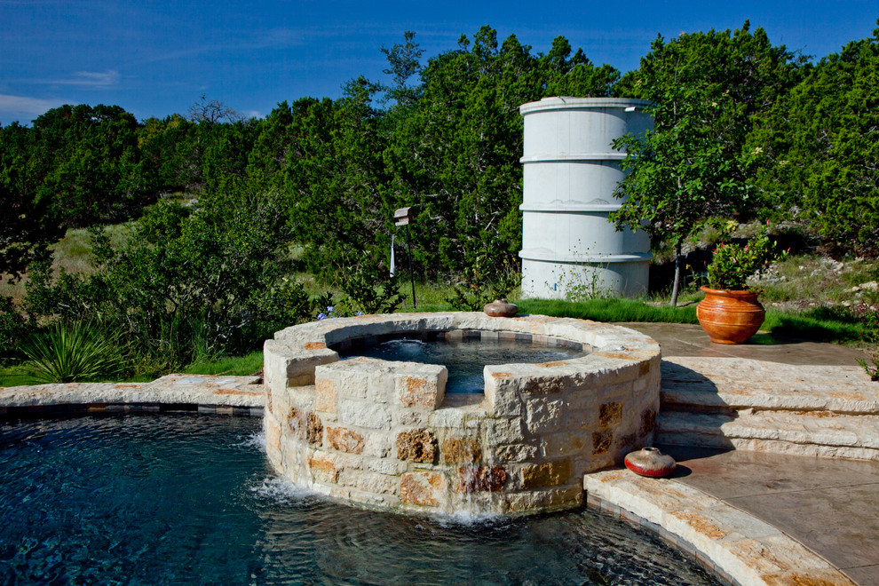 Mid-sized country backyard round aboveground pool in Austin with a water feature and stamped concrete.