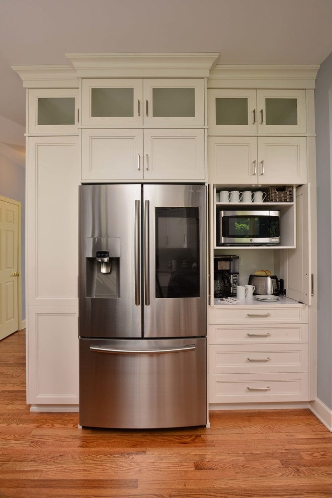 Inspiration for a large transitional l-shaped eat-in kitchen remodel with flat-panel cabinets, white cabinets, quartz countertops, stainless steel appliances and an island