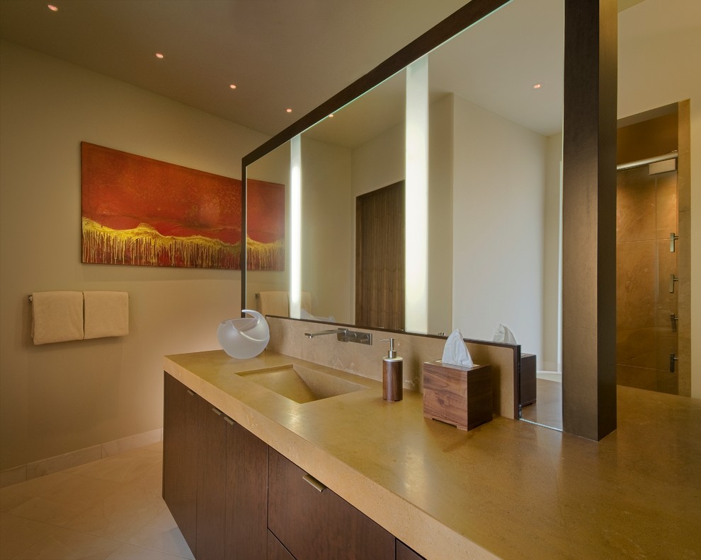 This is an example of a large contemporary master bathroom in Phoenix with an integrated sink, flat-panel cabinets, medium wood cabinets, limestone benchtops, a freestanding tub, an alcove shower, a one-piece toilet, beige tile, stone slab, white walls and limestone floors.