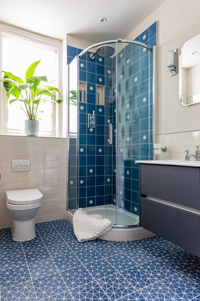 Inspiration for a classic bathroom in London with an alcove shower, a one-piece toilet, blue tiles, grey walls, blue floors and white worktops.