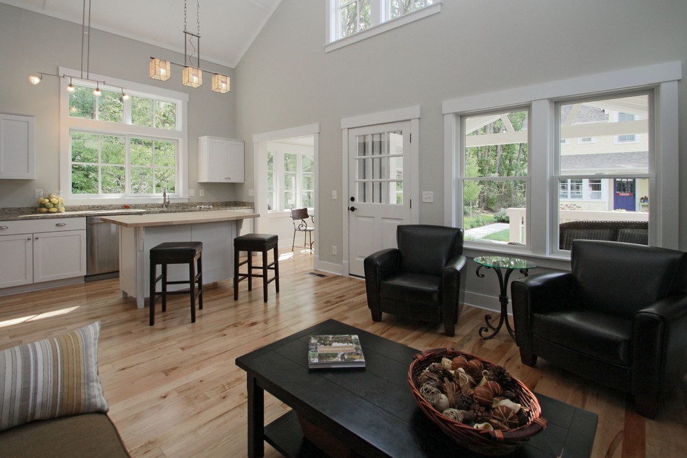 Arts and crafts open concept living room in Indianapolis with grey walls and light hardwood floors.