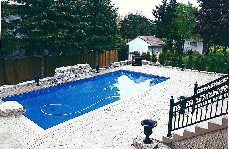 Inspiration for a large transitional backyard stone and rectangular pool remodel in Toronto