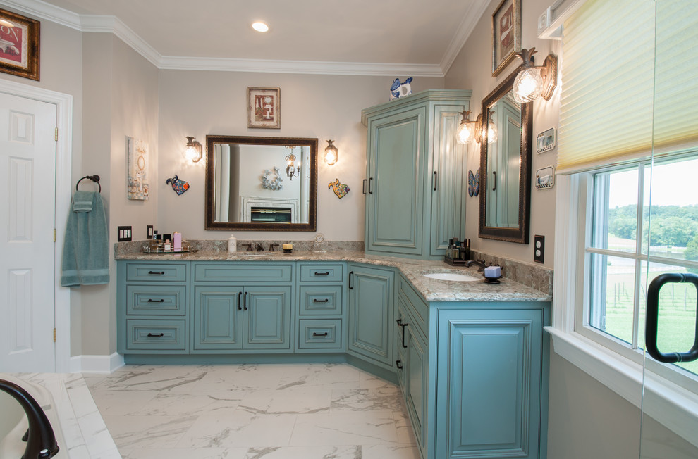 This is an example of a large mediterranean master bathroom in DC Metro with raised-panel cabinets, blue cabinets, a drop-in tub, a corner shower, an undermount sink, engineered quartz benchtops and a hinged shower door.