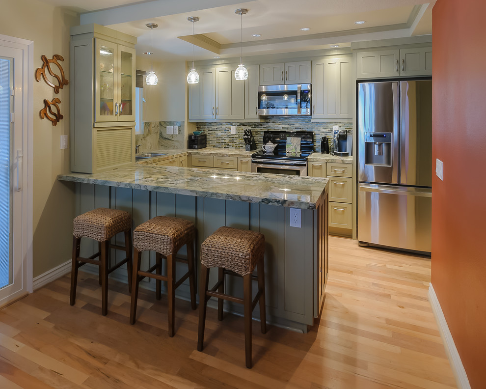 Inspiration for a small beach style u-shaped eat-in kitchen in San Diego with shaker cabinets, granite benchtops, stainless steel appliances, light hardwood floors, an undermount sink, grey cabinets, multi-coloured splashback, matchstick tile splashback, a peninsula and brown floor.