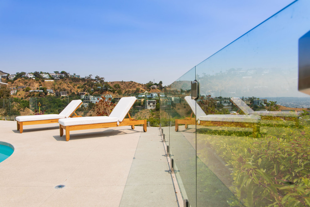Inspiration för mellanstora moderna terrasser på baksidan av huset, med räcke i glas
