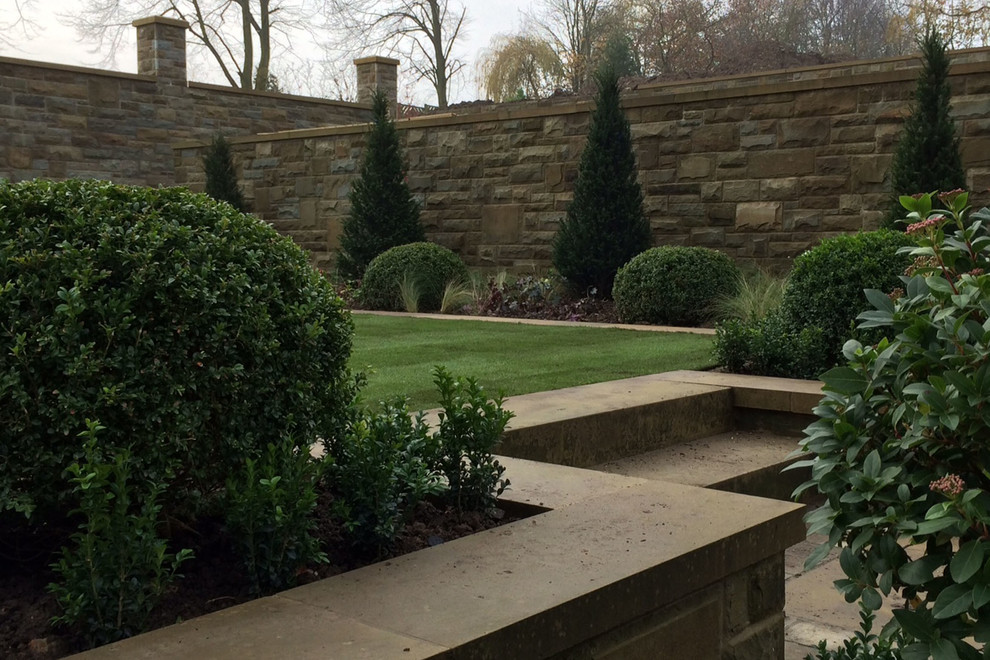 Design ideas for a large traditional sloped full sun formal garden for summer in Other with natural stone pavers.