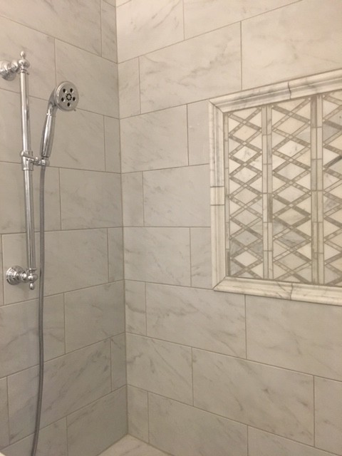 This is an example of a medium sized traditional ensuite bathroom in Charlotte with beaded cabinets, white cabinets, an alcove bath, an alcove shower, a two-piece toilet, white tiles, porcelain tiles, white walls, porcelain flooring, a submerged sink, marble worktops, a hinged door and white worktops.