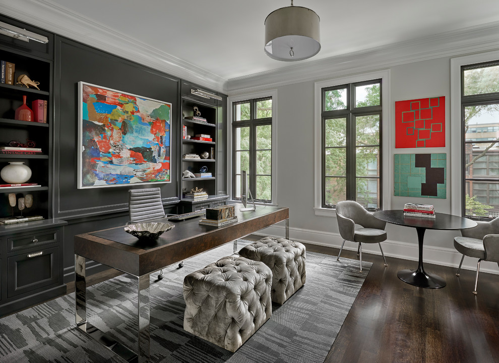 This is an example of a mid-sized transitional home office in Chicago with dark hardwood floors, a freestanding desk, brown floor and grey walls.