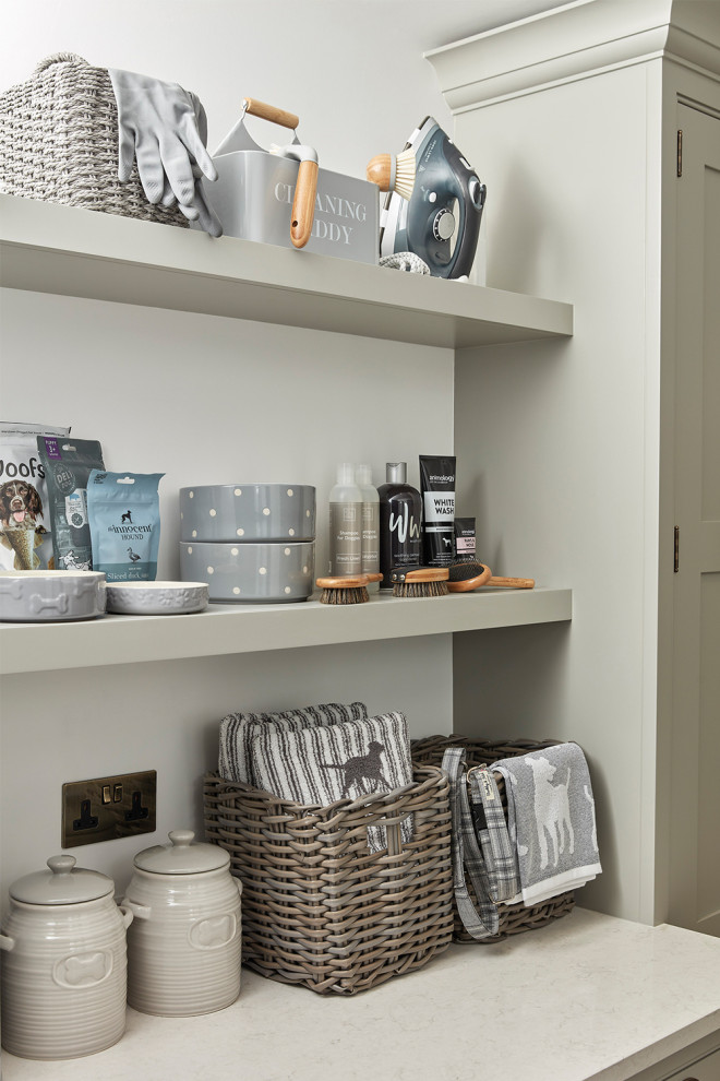 Design ideas for a small traditional laundry room in Hertfordshire with shaker cabinets, grey cabinets, quartz benchtops, white splashback, engineered quartz splashback, white walls, porcelain floors, a stacked washer and dryer, beige floor, white benchtop and panelled walls.
