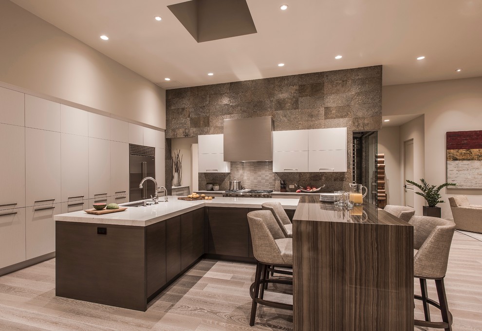 Design ideas for an expansive contemporary u-shaped open plan kitchen in Phoenix with an undermount sink, flat-panel cabinets, white cabinets, quartz benchtops, green splashback, slate splashback, stainless steel appliances, light hardwood floors, multiple islands, beige floor and white benchtop.