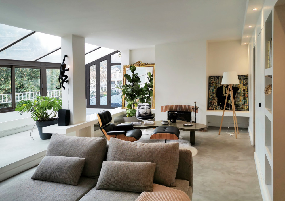 This is an example of a large contemporary formal open plan living room in Paris with white walls, concrete flooring, a brick fireplace surround, grey floors and a drop ceiling.