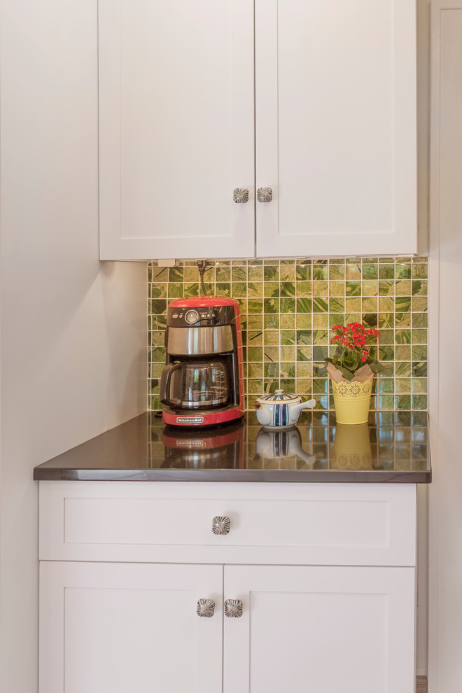Eat-in kitchen - mid-sized transitional l-shaped linoleum floor and red floor eat-in kitchen idea in Philadelphia with a double-bowl sink, shaker cabinets, white cabinets, quartzite countertops, green backsplash, glass tile backsplash, stainless steel appliances and black countertops