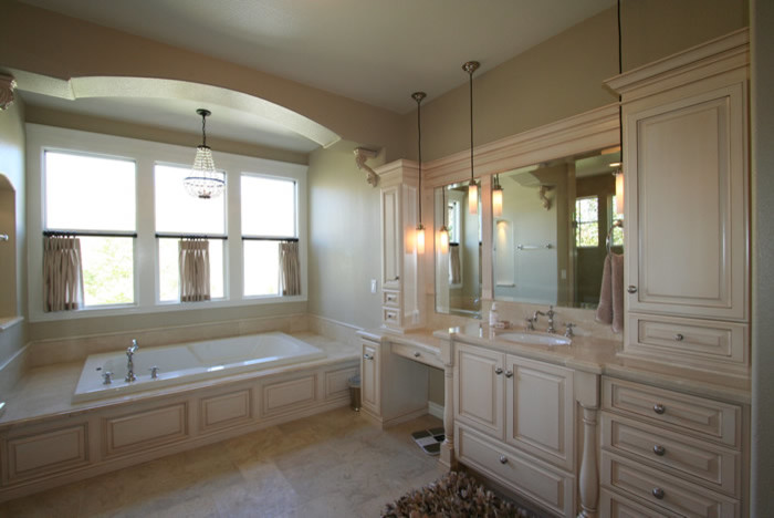 Inspiration for a traditional bathroom in Los Angeles with an undermount sink, furniture-like cabinets, beige cabinets, marble benchtops, a drop-in tub, an open shower, beige tile and stone tile.