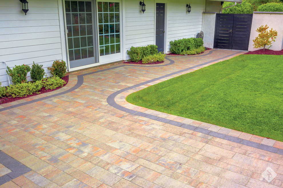 This is an example of a small traditional courtyard patio in Orange County with a fire feature and concrete pavers.