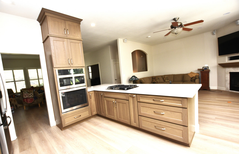 Kitchen - large transitional u-shaped vinyl floor and brown floor kitchen idea with an undermount sink, shaker cabinets, medium tone wood cabinets, quartzite countertops, beige backsplash, porcelain backsplash, stainless steel appliances, an island and beige countertops