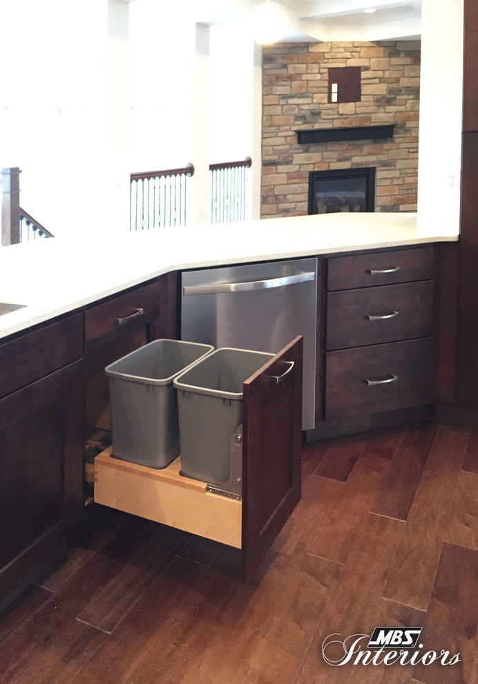 Inspiration for a large transitional medium tone wood floor and brown floor eat-in kitchen remodel with an undermount sink, shaker cabinets, stainless steel appliances, dark wood cabinets and a peninsula