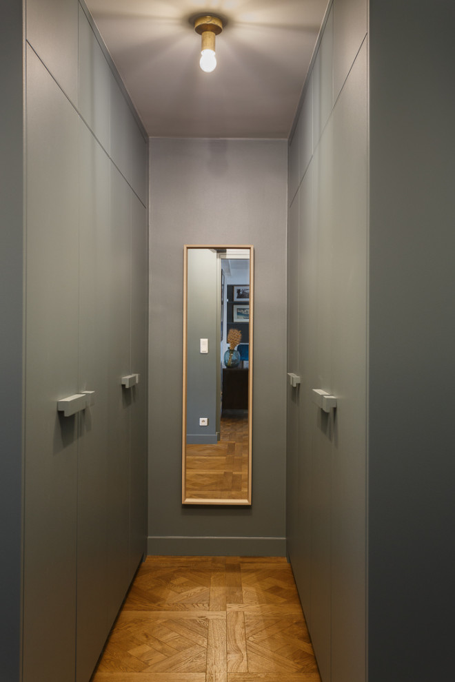 Источник вдохновения для домашнего уюта: гардеробная комната среднего размера, унисекс в скандинавском стиле с плоскими фасадами, серыми фасадами, светлым паркетным полом и бежевым полом