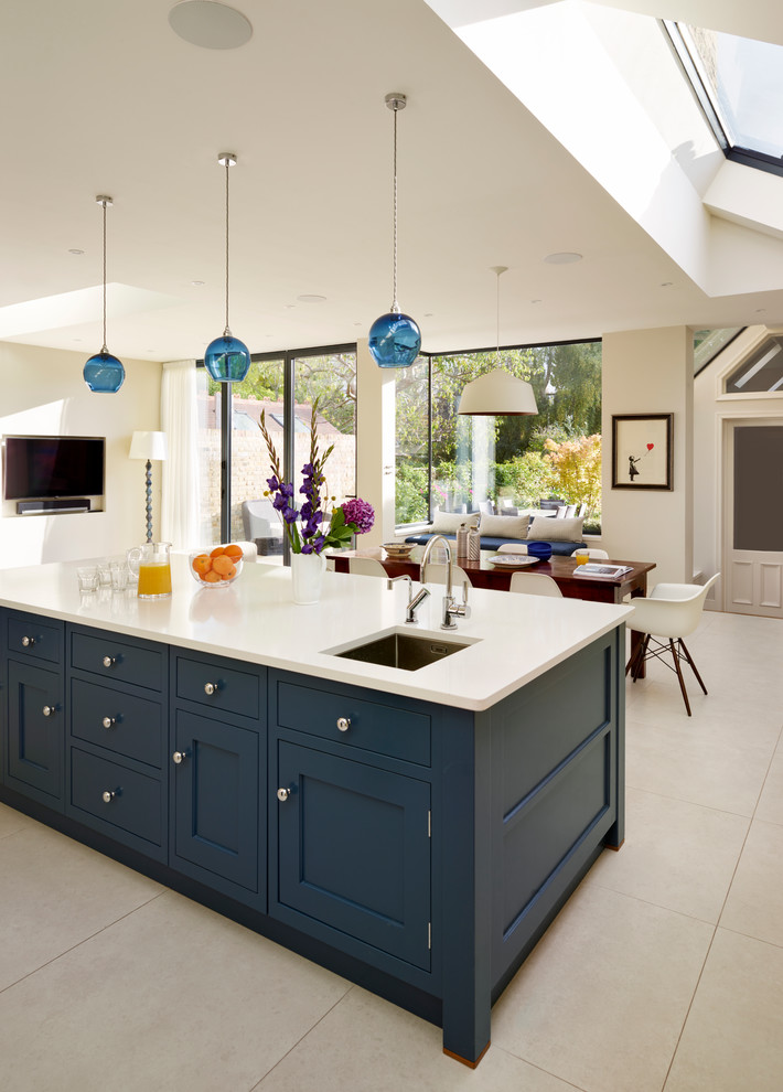 Photo of an expansive contemporary open plan kitchen in London with shaker cabinets and with island.