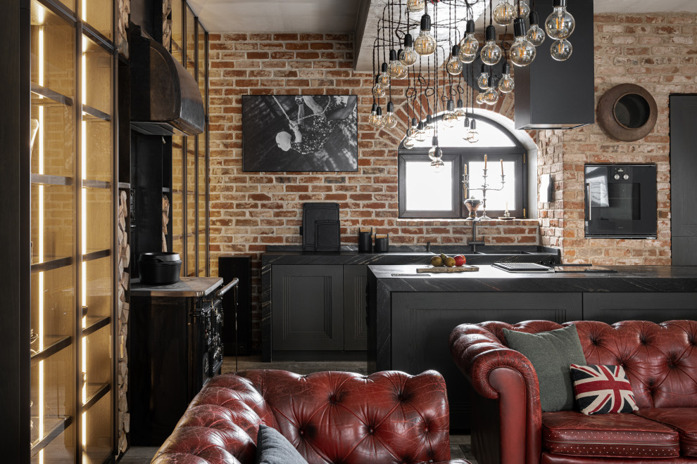 Foto på ett mellanstort industriellt svart kök, med en dubbel diskho, marmorbänkskiva, rött stänkskydd, stänkskydd i tegel, svarta vitvaror, en köksö och grått golv