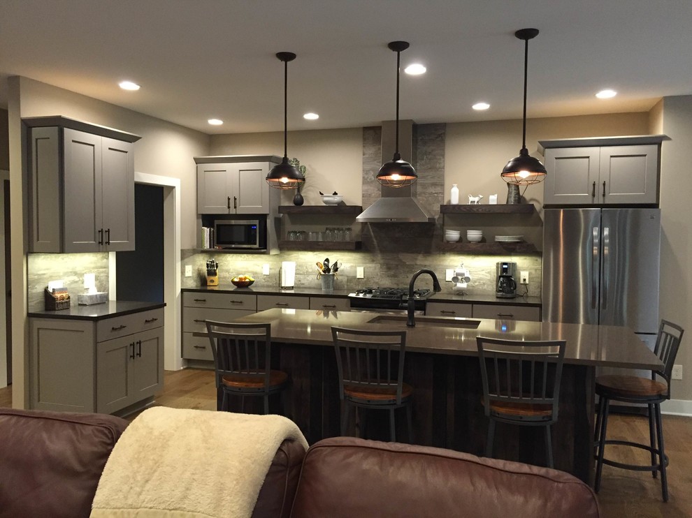 Open concept kitchen - large transitional l-shaped dark wood floor and brown floor open concept kitchen idea in Grand Rapids with flat-panel cabinets, an island, an undermount sink, gray cabinets, quartzite countertops, brown backsplash, wood backsplash, stainless steel appliances and gray countertops