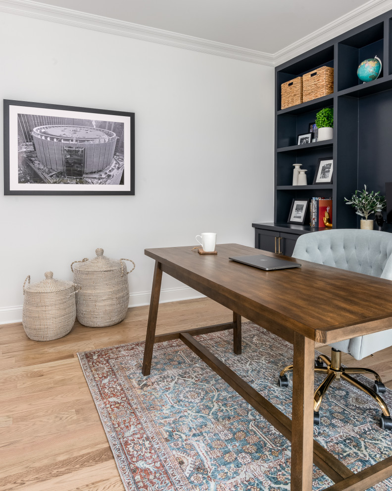 Mittelgroßes Klassisches Arbeitszimmer mit grauer Wandfarbe, hellem Holzboden, Einbau-Schreibtisch und braunem Boden in New York