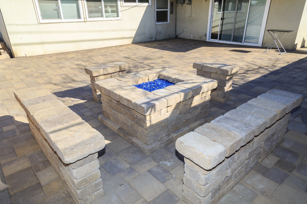 Photo of a mid-sized contemporary backyard patio in Los Angeles with a fire feature, brick pavers and no cover.