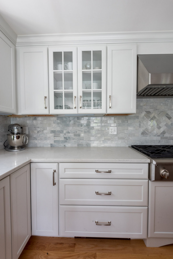 Inspiration for a large transitional l-shaped medium tone wood floor, brown floor and coffered ceiling eat-in kitchen remodel in Boston with an undermount sink, shaker cabinets, white cabinets, quartz countertops, gray backsplash, subway tile backsplash, stainless steel appliances, an island and white countertops