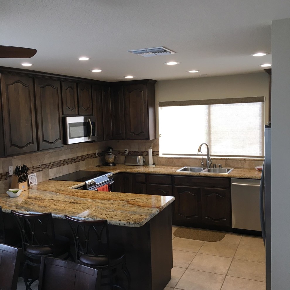 Eat-in kitchen - small transitional u-shaped eat-in kitchen idea in Phoenix with a drop-in sink, beaded inset cabinets, granite countertops, stone tile backsplash, stainless steel appliances and no island